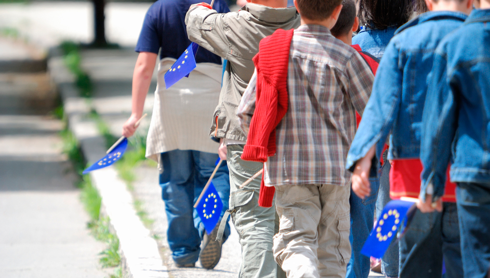Kuvassa lapset kulkevat jonossa Eu-liput kädessään. Kuva: Shutterstock